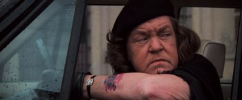 Movie still from “The Goonies” (1985), directed by Richard Donner – An older woman with a tattoo on her arm; Close Up shot, Over the shoulder angle