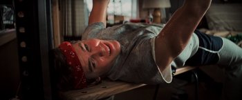 Movie still from “The Goonies” (1985), directed by Richard Donner – A man laying on the ground wearing a bandanna; Medium shot, Overhead angle