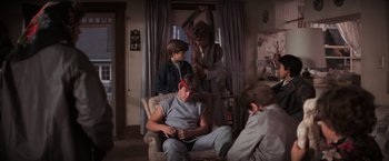 Movie still from “The Goonies” (1985), directed by Richard Donner – A group of young people sitting in a living room; Wide shot, Over the shoulder angle