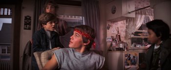 Movie still from “The Goonies” (1985), directed by Richard Donner – A young man with a bandanna around his head; Medium shot, Over the shoulder angle