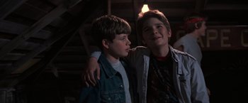 Movie still from “The Goonies” (1985), directed by Richard Donner – Two young boys standing next to each other in the dark; Close Up shot, Low angle