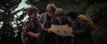 Movie still from “The Goonies” (1985), directed by Richard Donner – A group of young people looking at a map; Medium shot, High angle