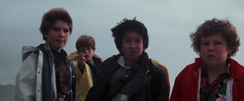 Movie still from “The Goonies” (1985), directed by Richard Donner – A group of young people standing next to each other; Close Up shot, Low angle
