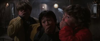 Movie still from “The Goonies” (1985), directed by Richard Donner – A group of young people sitting next to each other; Close Up shot, Low angle