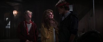 Movie still from “The Goonies” (1985), directed by Richard Donner – A group of people standing next to each other in a dark room; Medium shot, Over the shoulder angle