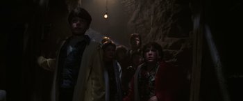 Movie still from “The Goonies” (1985), directed by Richard Donner – A group of people standing in a dark cave; Medium shot, Low angle