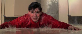 Movie still from “The Goonies” (1985), directed by Richard Donner – A man in a red jacket laying on the ground; Close Up shot, Low angle