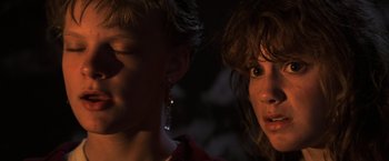 Movie still from “The Goonies” (1985), directed by Richard Donner – Two women standing next to each other in the dark; Close Up shot, Over the shoulder angle