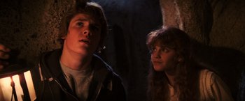 Movie still from “The Goonies” (1985), directed by Richard Donner – A young man and a young woman standing next to each other; Close Up shot, Low angle