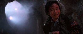 Movie still from “The Goonies” (1985), directed by Richard Donner – A young man smiles while holding a video game controller; Close Up shot, Low angle