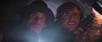 Movie still from “The Goonies” (1985), directed by Richard Donner – Two men are looking into the distance in the dark; Close Up shot, Low angle