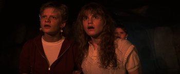 Movie still from “The Goonies” (1985), directed by Richard Donner – A woman with long brown hair is looking surprised; Close Up shot, Low angle