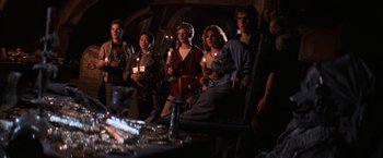 Movie still from “The Goonies” (1985), directed by Richard Donner – A group of people holding lit candles in a dark room; Medium shot, High angle