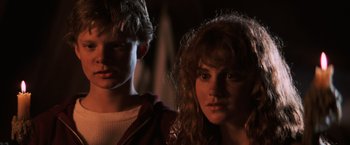 Movie still from “The Goonies” (1985), directed by Richard Donner – A man and a woman standing next to each other; Close Up shot, Low angle