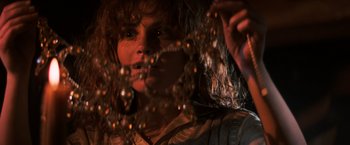 Movie still from “The Goonies” (1985), directed by Richard Donner – A woman with long curly brown hair is looking at the camera; Close Up shot, Low angle