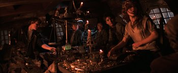 Movie still from “The Goonies” (1985), directed by Richard Donner – A group of people sitting around a table with candles; Medium shot, High angle