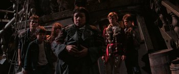 Movie still from “The Goonies” (1985), directed by Richard Donner – A group of people standing next to each other; Medium shot, Low angle