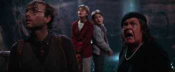 Movie still from “The Goonies” (1985), directed by Richard Donner – A group of people standing next to each other in a cave; Medium shot, Over the shoulder angle
