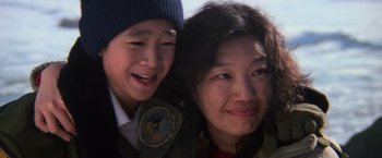 Movie still from “The Goonies” (1985), directed by Richard Donner – A woman and a boy smiling for the camera; Close Up shot, Low angle