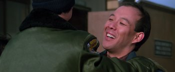 Movie still from “The Goonies” (1985), directed by Richard Donner – A man in a green jacket is laughing with another man in a green jacket; Close Up shot, Over the shoulder angle