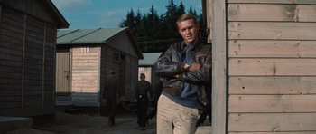 Movie still from “The Great Escape” (1963), directed by John Sturges – A man standing in front of a group of men; Medium shot, Low angle