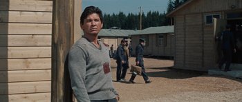 Movie still from “The Great Escape” (1963), directed by John Sturges – A man standing in front of a group of men; Medium shot, Over the shoulder angle