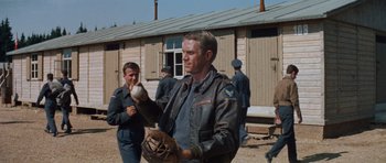 Movie still from “The Great Escape” (1963), directed by John Sturges – A man holding a baseball in his hands; Medium shot, Over the shoulder angle