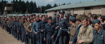 Movie still from “The Great Escape” (1963), directed by John Sturges – A large group of men in uniform standing next to each other; Wide shot, High angle