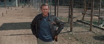 Movie still from “The Great Escape” (1963), directed by John Sturges – A man standing in front of a wire fence; Medium shot, Low angle
