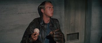 Movie still from “The Great Escape” (1963), directed by John Sturges – A man holding a baseball mitt and a ball; Close Up shot, High angle
