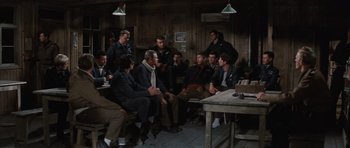 Movie still from “The Great Escape” (1963), directed by John Sturges – A group of men sitting around a table in a room; Wide shot, High angle