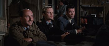 Movie still from “The Great Escape” (1963), directed by John Sturges – A group of men sitting next to each other on a couch; Medium shot, High angle
