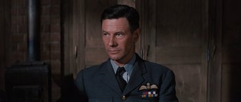 Movie still from “The Great Escape” (1963), directed by John Sturges – A person wearing a suit and tie; Close Up shot, Low angle