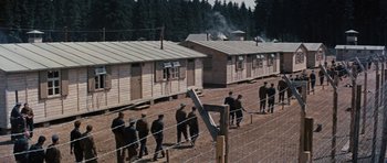 Movie still from “The Great Escape” (1963), directed by John Sturges – A group of men standing in front of a building; Extreme Wide shot, High angle