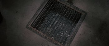 Movie still from “The Great Escape” (1963), directed by John Sturges – An open metal grate on the floor of a building; Extreme Close Up shot, Overhead angle