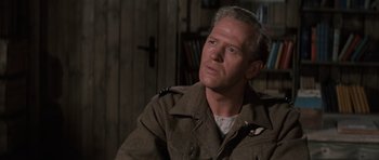 Movie still from “The Great Escape” (1963), directed by John Sturges – A person sitting in a room; Close Up shot, Over the shoulder angle