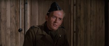 Movie still from “The Great Escape” (1963), directed by John Sturges – A man in a military uniform wearing a hat; Close Up shot, Low angle