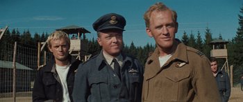 Movie still from “The Great Escape” (1963), directed by John Sturges – Two men standing next to each other in uniform; Medium shot, Low angle