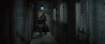 Movie still from “The Great Escape” (1963), directed by John Sturges – Two men are walking down a dark hallway; Wide shot, High angle
