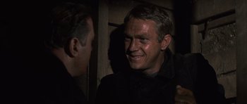 Movie still from “The Great Escape” (1963), directed by John Sturges – A man smiling while standing next to another man; Close Up shot, Over the shoulder angle