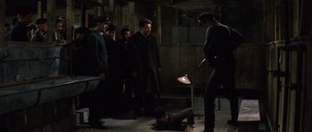 Movie still from “The Great Escape” (1963), directed by John Sturges – A group of men standing next to each other in a room; Wide shot, High angle