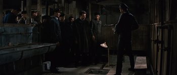 Movie still from “The Great Escape” (1963), directed by John Sturges – A group of men standing in a room; Wide shot, High angle