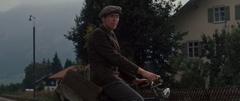 Movie still from “The Great Escape” (1963), directed by John Sturges – A man riding on the back of a motorcycle; Medium shot, Low angle