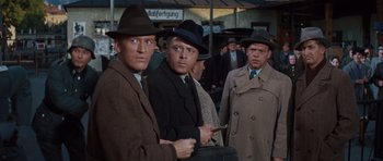 Movie still from “The Great Escape” (1963), directed by John Sturges – A group of men standing next to each other in a crowd; Medium shot, Over the shoulder angle