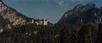 Movie still from “The Great Escape” (1963), directed by John Sturges – A castle on top of a hill with trees in the foreground; Extreme Wide shot, Low angle
