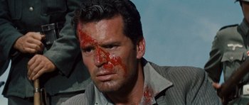 Movie still from “The Great Escape” (1963), directed by John Sturges – A person with blood all over his face; Close Up shot, High angle