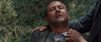 Movie still from “The Great Escape” (1963), directed by John Sturges – A man laying in the grass with a blood spot on his face; Close Up shot, Overhead angle
