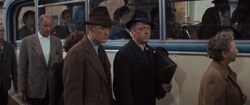 Movie still from “The Great Escape” (1963), directed by John Sturges – A couple of men standing next to each other on a bus; Medium shot, Over the shoulder angle