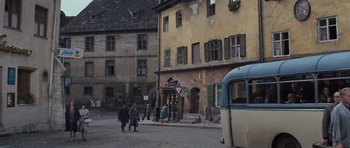 Movie still from “The Great Escape” (1963), directed by John Sturges – People are walking down the street near a bus; Wide shot, High angle