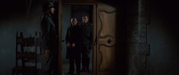 Movie still from “The Great Escape” (1963), directed by John Sturges – A couple of men standing next to each other in front of a door; Medium shot, Over the shoulder angle